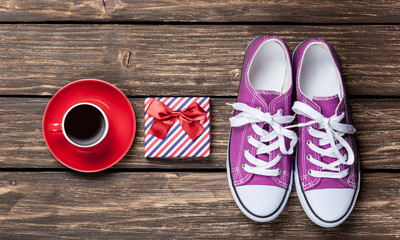 Gumshoes and gift box with coffee cup