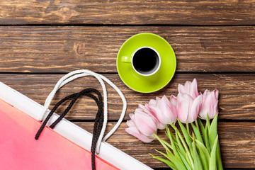 Bags with cup of coffee and tulips