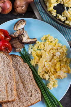 serving healthy brunch, scrambled egg with vegetables, from abov