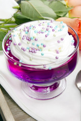 Colorful jelly with whipped cream and candy topping