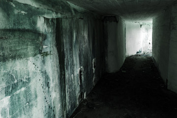 Empty abandoned bunker interior with glowing end