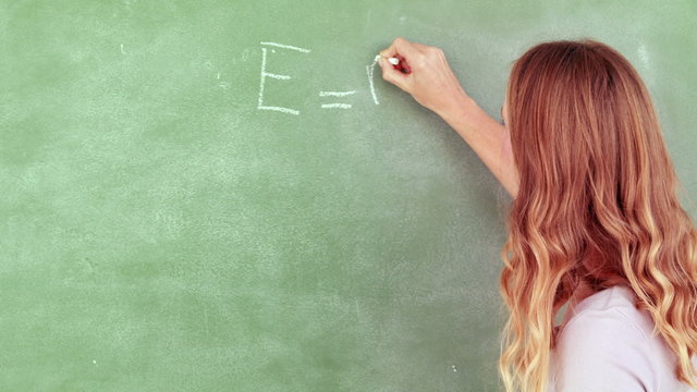 Teacher writing e = mc squared