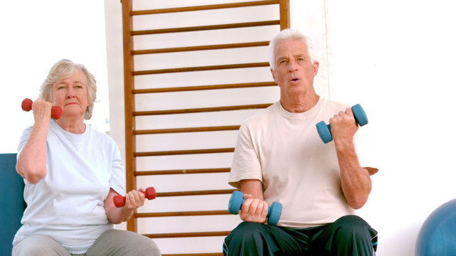 Active seniors lifting hand weights