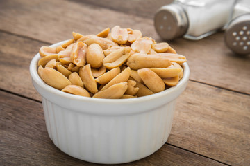Peanuts in white bowl and salt shaker