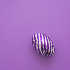 easter eggs with stripes, on a plain purple background