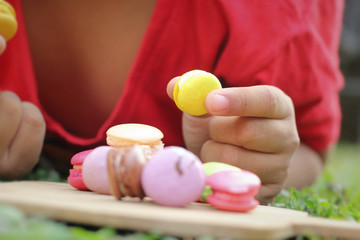 Kid eating french macaroons is delicious