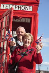 Senior couple with red telephone box in London