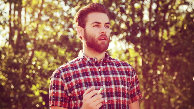 Handsome hipster smoking an electronic cigarette