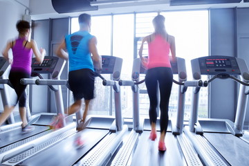 Obraz na płótnie Canvas Group of people running on treadmills
