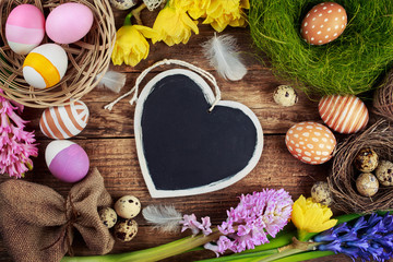Fototapeta na wymiar Chalk board in the shape of hearts and Easter decorations