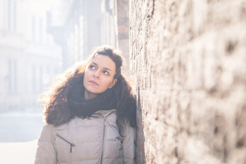 Beautiful young brunette posing in the city streets