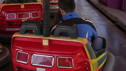 Father and his two sons, going on a bumper car in amusement park