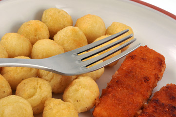 Gros plan sur des poissons panés et pommes noisettes