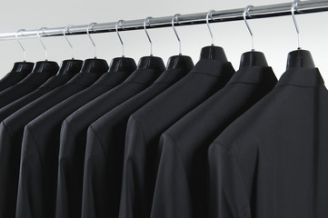 Row of men's suit jackets hanging