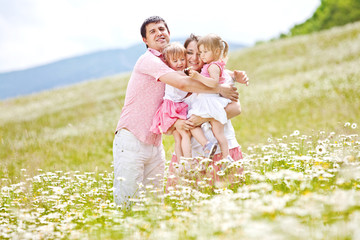 Happy young family in flowers field