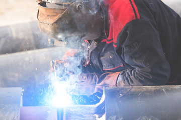 Welding pipes on a construction site.