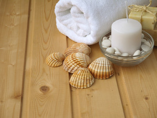 Towel,soap,candle and shells on the wooden background