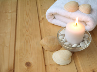 Towel,shells and burning candle on the wooden background