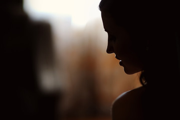 Silhouette of a bride on a background of a window