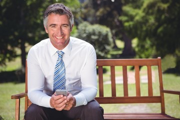 Fototapeta premium Businessman using his phone in the park
