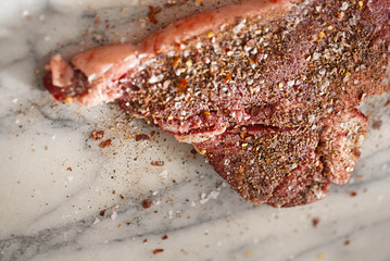 beef steak t-bone with vintage meat fork on marble backdrop