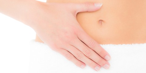 Mid section of a fit woman with hand on stomach