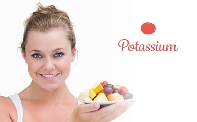 Potassium against woman holding up a plate fruits