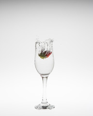 Strawberry falls deeply under water with a splash