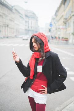 Young woman using smartphone while standing on street