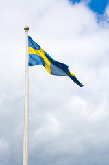 Swedish flag blue with yellow cross against cloud