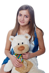 Young cheerful girl holding big soft toy bear isolated on white