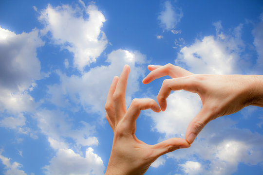Hands with heart shape on the sky