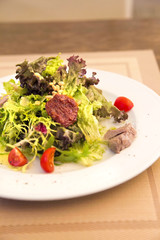 Green salad with chicken meat, dried tomatoes and pine nuts