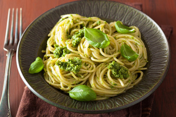 spaghetti pasta with pesto sauce over rustic table
