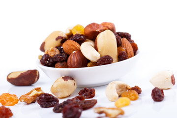 Obraz na płótnie Canvas Mixed nuts and sultanas on a plate on a white background