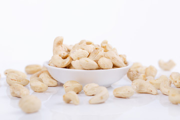 Cashew nuts on plate isolated on the white background