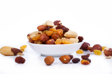Mixed nuts and sultanas on a plate on a white background