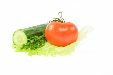Half cucumber, tomato, dill on a piece of lettuce