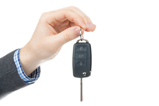 Male hand giving car keys - studio shot on white background