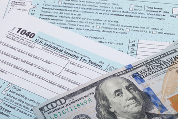 Obraz premium US 1040 Tax Form and dollars - studio shot