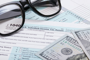 US 1040 Tax Form, glasses and dollars - studio shot