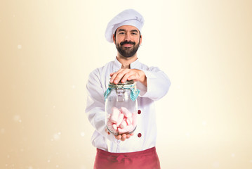 Chef holding jar glass with sweetmeats inside