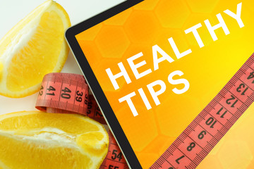 Tablet with words healthy tips and measuring tape
