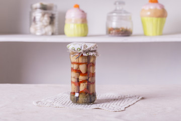 a small glass jar with conservation, corn, peppers, mushrooms