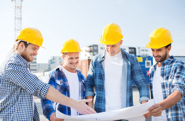 group of builders with tablet pc and blueprint