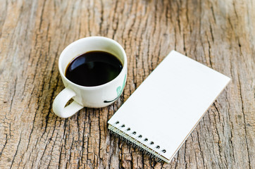 Obraz na płótnie Canvas Notebook and coffee cup on wooden board