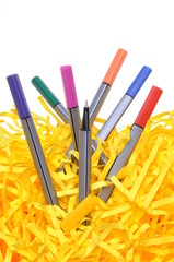 Markers with yellow shredded papers