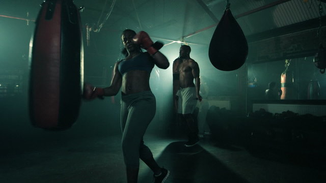 Group of Boxers Training in a Group. Female in the foreground.Male skipping in the background