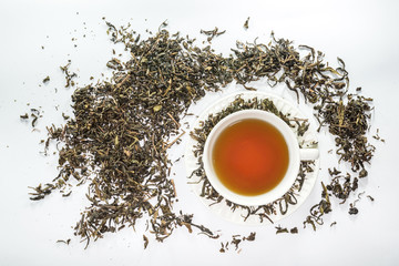 White cup of tea with dried tea leaf on the white background