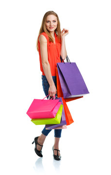 Happy caucasian woman holding shopping bags on white. Holidays c